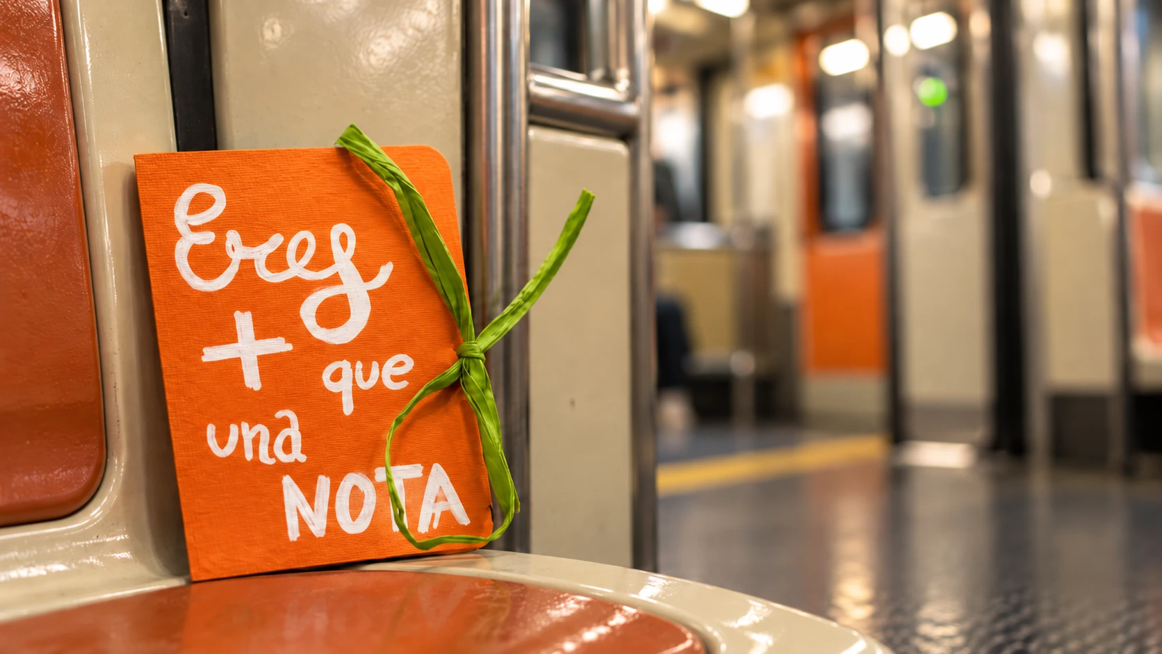 Cartita naranja en un asiento del metro